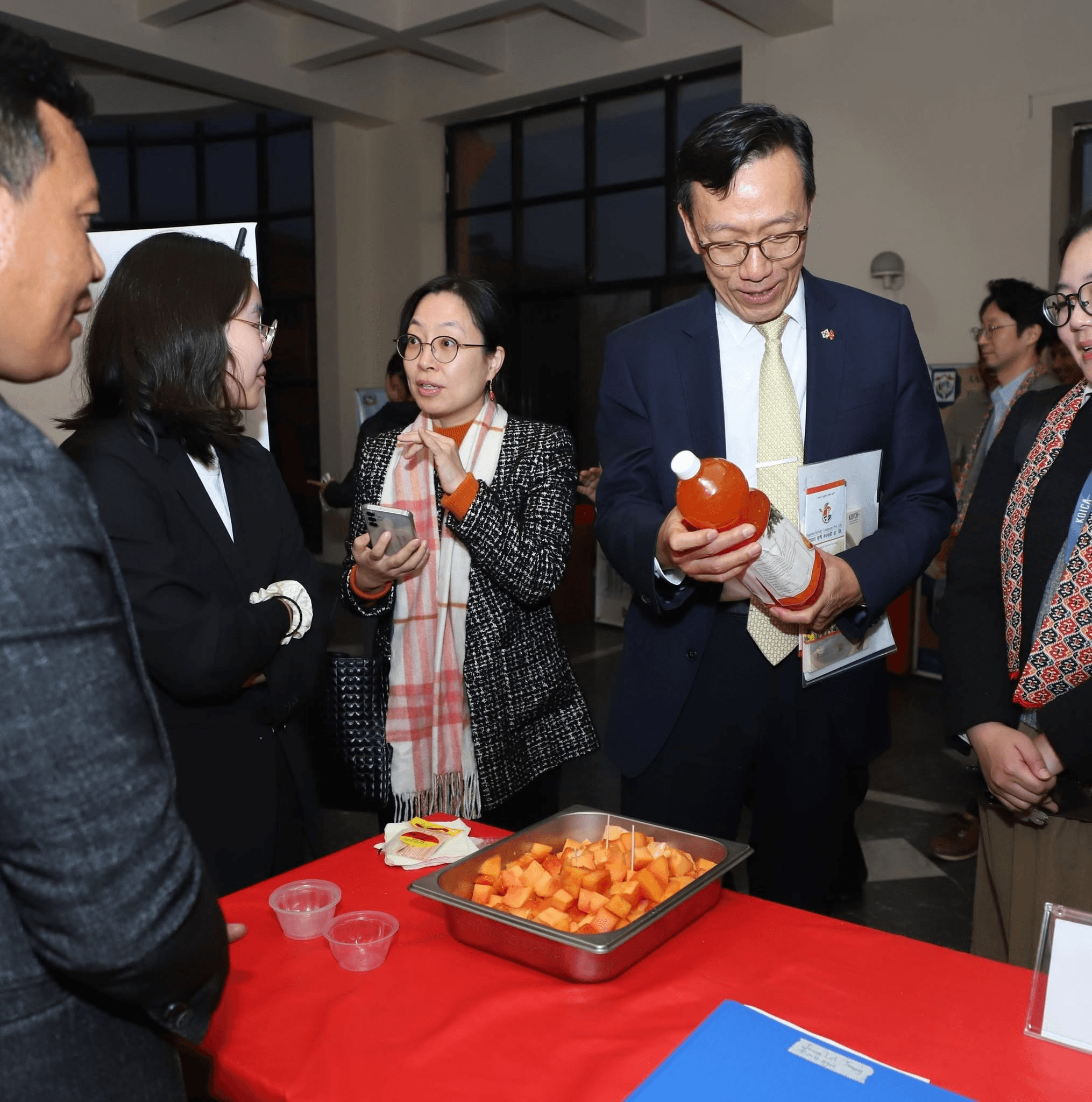 Guests examining a T.M.G Agro papaya drink at a recognition event